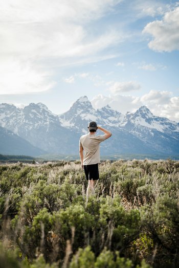 Voir loin, avec sécurité Homme contemplant les montagnes – projection d’avenir assurée